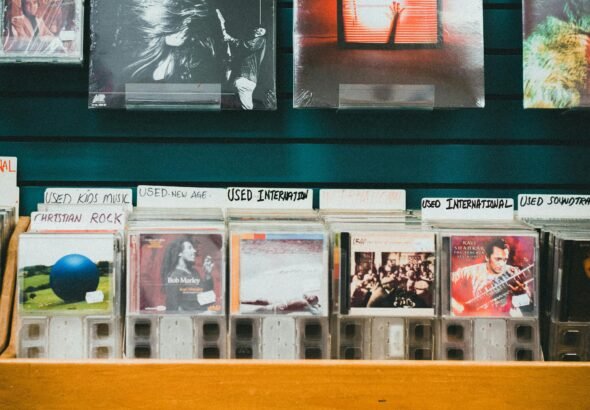 A nostalgic music store display featuring vinyl records and CDs on wooden shelves.