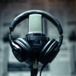 Microphone with headphones in a studio environment, perfect for sound recording and podcasting.