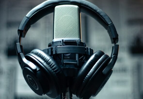 Microphone with headphones in a studio environment, perfect for sound recording and podcasting.